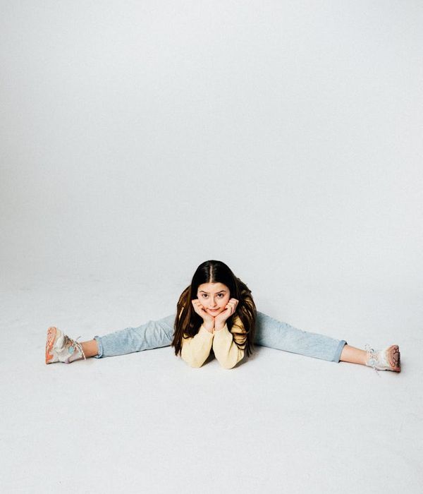 Happy children doing a playful yoga pose in a sunlit studio.